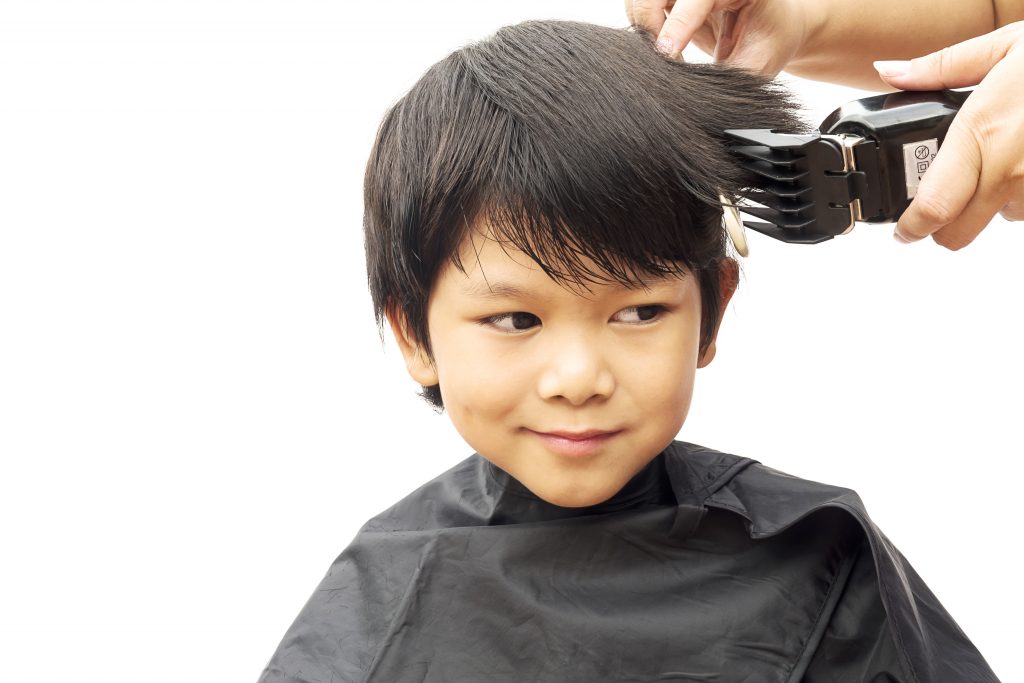 young boy having a haircut at stylette
